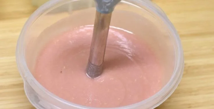Cold process salt bar soap in loaf molds with ingredients and tools for soap making.